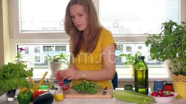 坐在厨房的<strong>餐桌</strong>旁吃小<strong>番茄</strong>蔬菜的孕妇